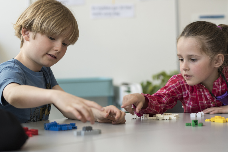 två barn bygger med lego