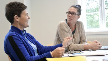 Två lärare som samtalar vid ett bord.