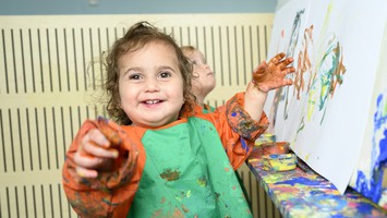 Barn i förskolan som målar med händerna.