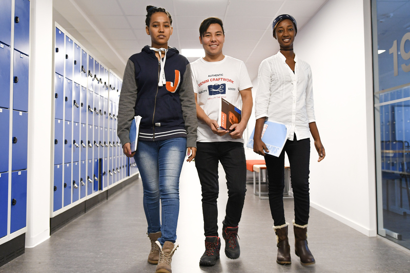 tre elever går i skolkorridoren